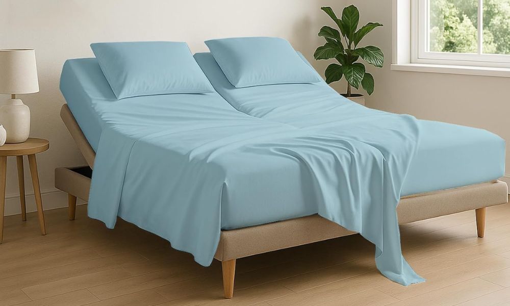 Adjustable bed with light blue bedding in a cozy bedroom setting featuring wooden floors and green plants