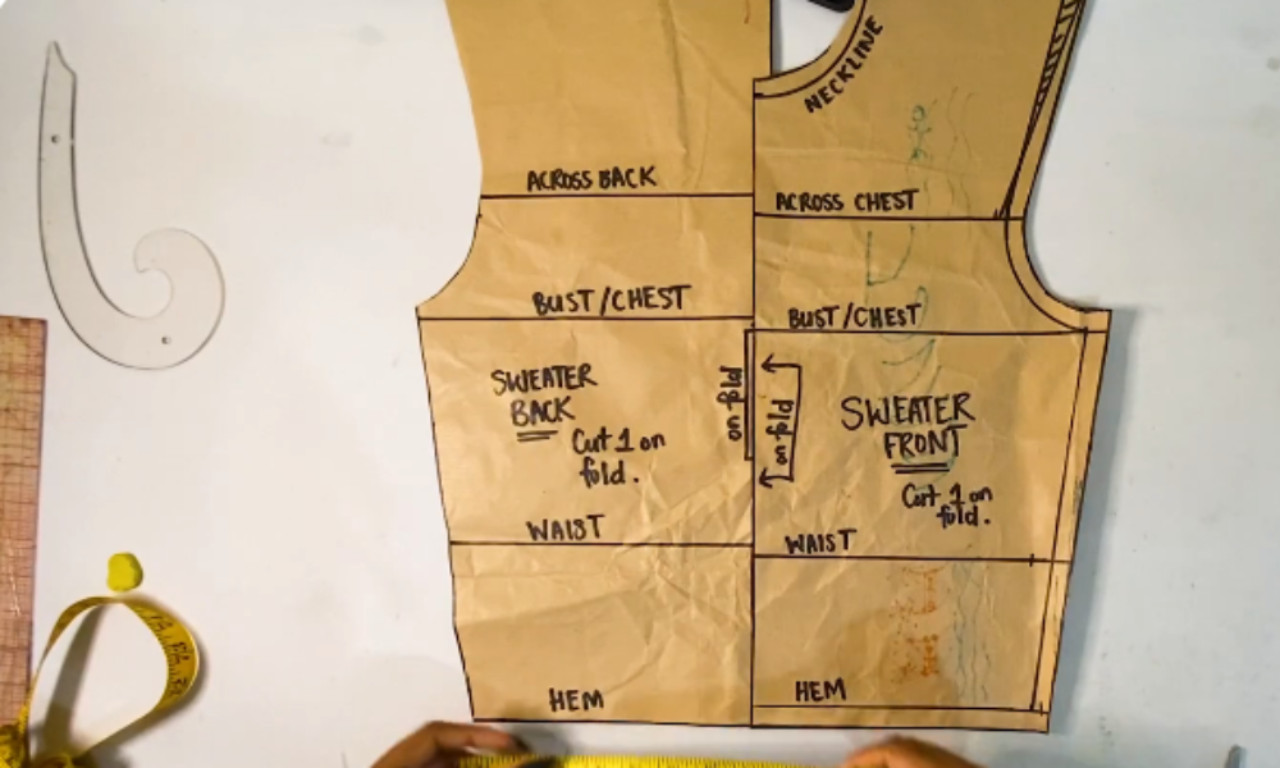 Finished paper sewing pattern for a sweater's front and back, labeled with terms like "Bust/Chest" and "Waist" and instructions to "Cut 1 on fold."