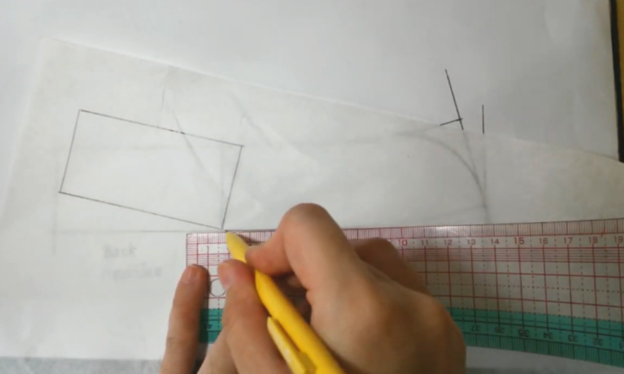A person's hand using a clear gridded ruler and a yellow pencil to draft a sewing pattern for a Mandarin collar on white tracing paper.