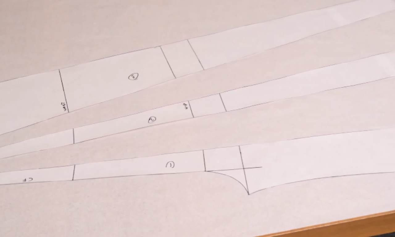 The completed paper pattern pieces for the DIY halter neck jumpsuit laid out on a table before being pinned to fabric.