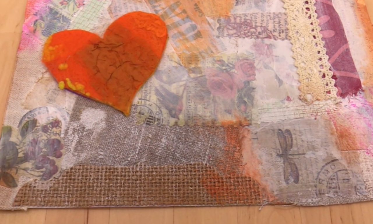 A mixed-media collage with a large, textured orange heart as the focal point. The background is a layered composition of burlap, cream-colored lace, and various papers with vintage designs including floral prints, postage stamps, and a dragonfly.