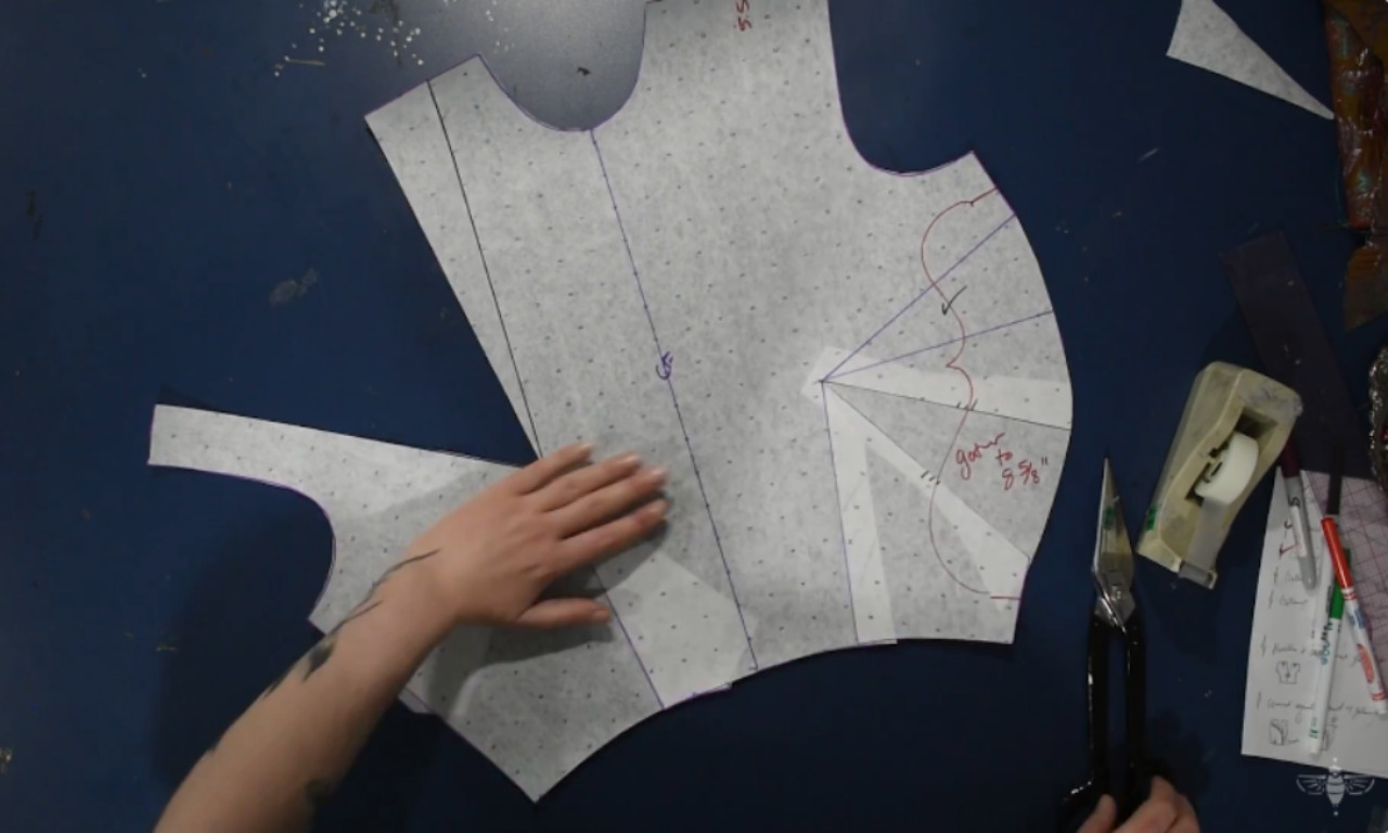A sewer uses the slash and spread method on a paper bodice pattern to create room for the gathers.