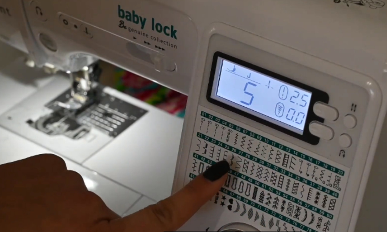 A close-up of a Baby Lock sewing machine screen with a finger selecting stitch pattern number 25 from the stitch options chart.