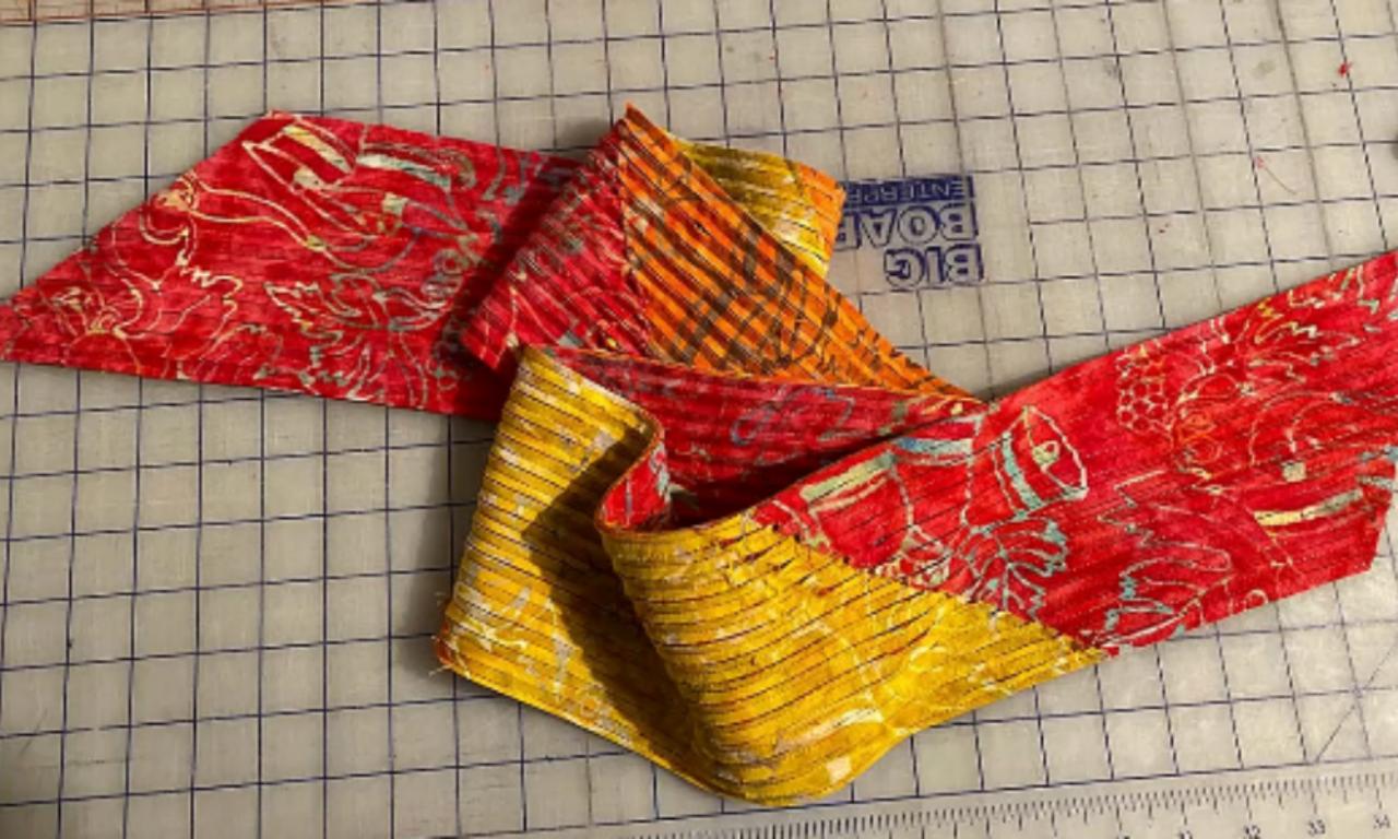 Colorful flannel strips cut on a 45-degree bias, folded and ready to be layered for a DIY chenille scarf.