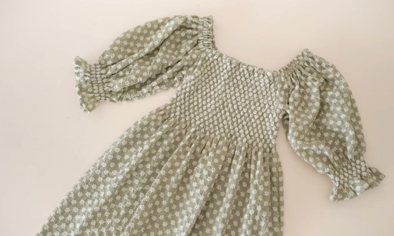 A completed off-shoulder dress with long puff sleeves attached, featuring shirring on the bodice and cuffs.
