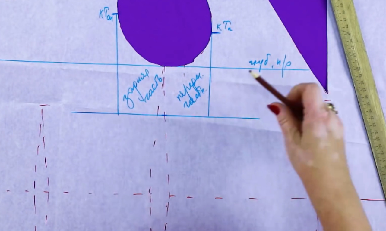 A close-up view of a sewing pattern shows handwritten notes in blue ink in Russian, with sections labeled for the front and back parts of a garment. The person is pointing with a pencil at one of the labeled areas on the tracing paper.