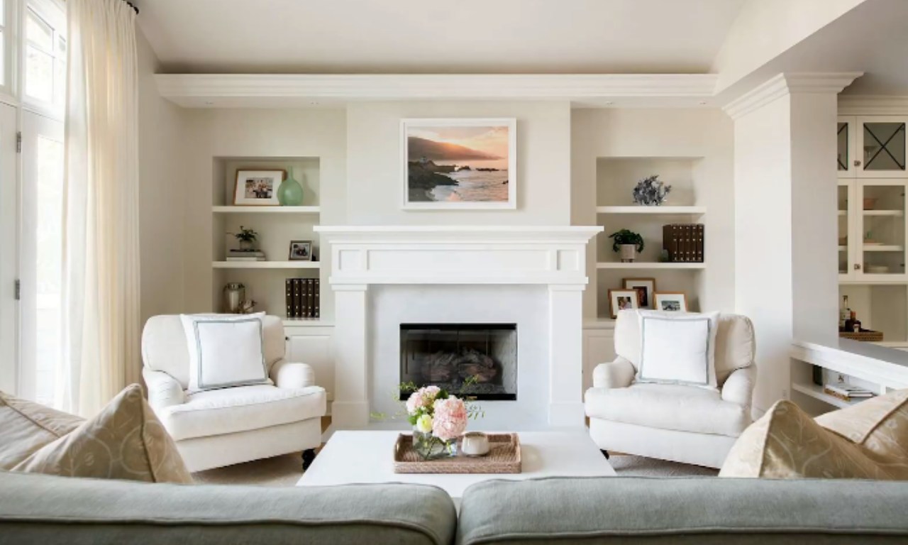 A light-filled living room showing sheer white curtains mounted high and wide