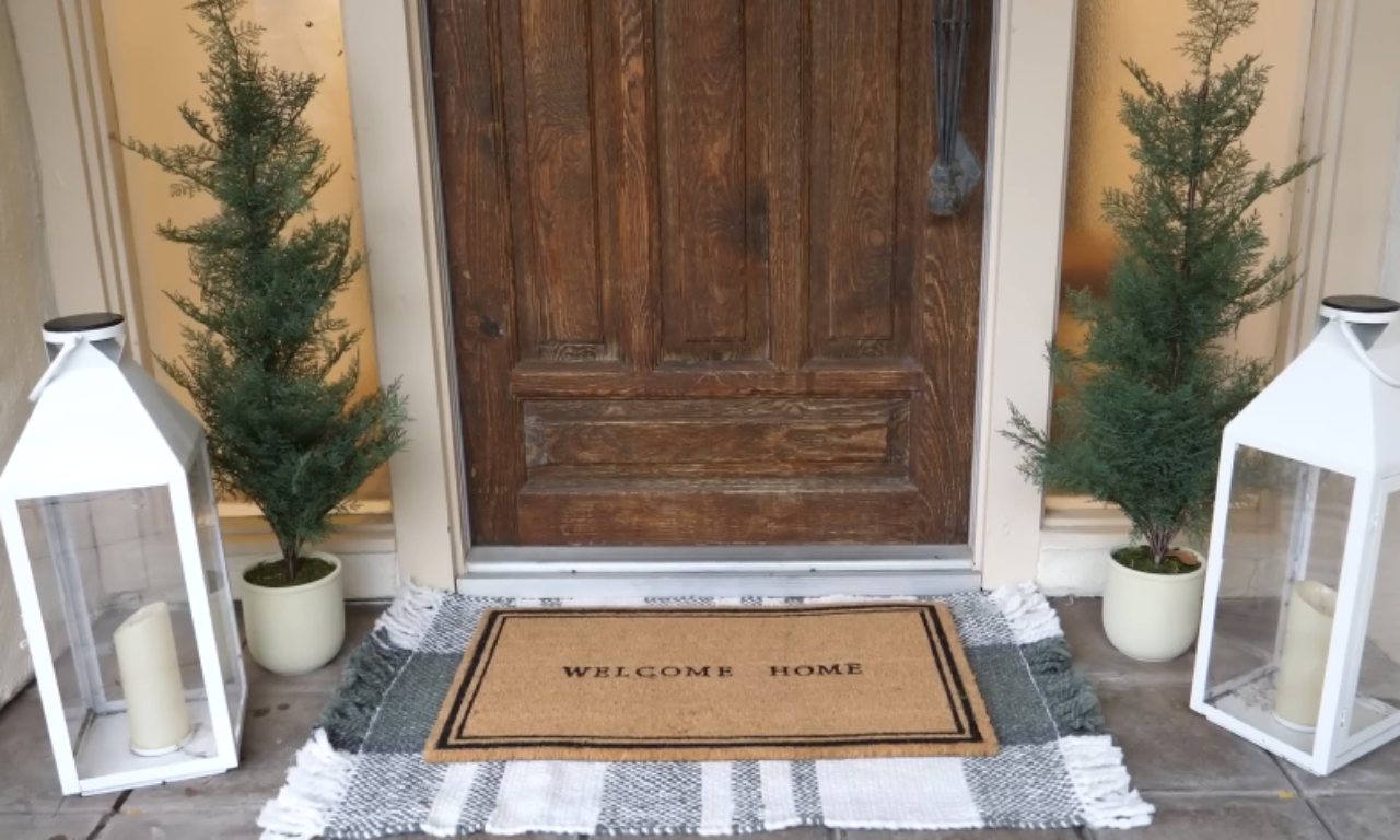 Create a welcoming doorstep with layered doormats and soft lantern light