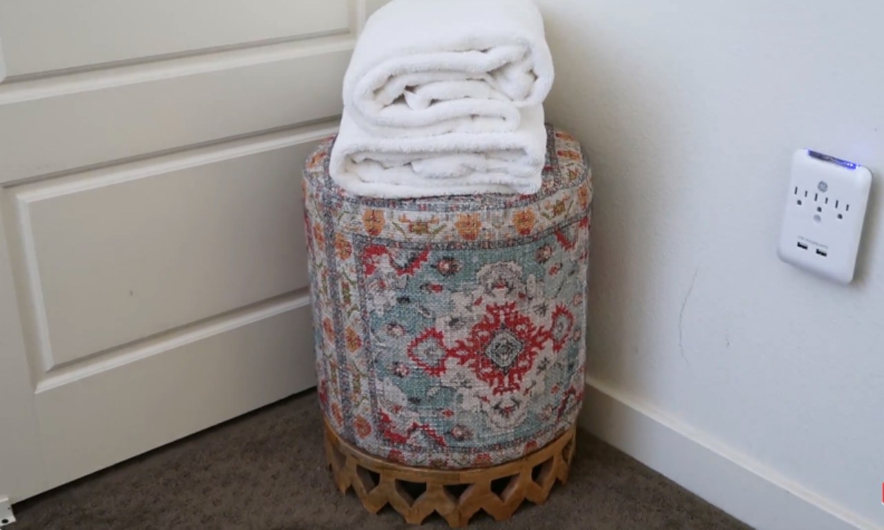 Fresh towels stacked on an ottoman