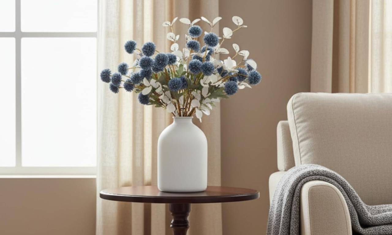 Home large white matte iron vase on a wooden side table with artificial eucalyptus branches and blue pom pom flowers, styled as Amazon household essentials in a minimalist living room.