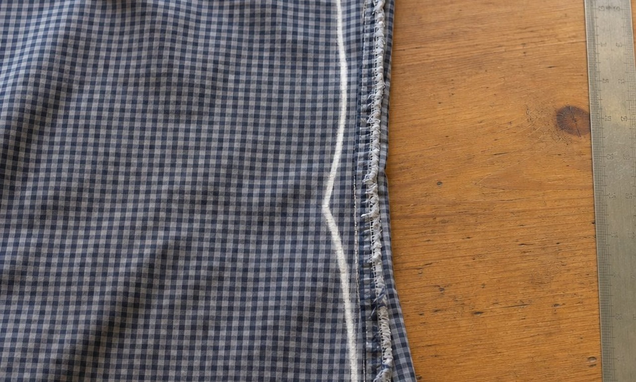 Tailor's chalk lines curving in at the waist and back out to the hem along the inside of a men's shirt side seam